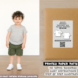 Può includere: Un bambino piccolo con una maglietta grigia e pantaloncini cargo verdi è in piedi accanto a una busta di cartamodello marrone. La busta ha un'etichetta che dice "BOYS POCKET PATCHED TEE SEWING PATTERN". Ulteriore testo sulla busta include "PRINTED PAPER PATTERN".
