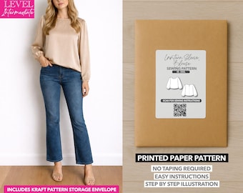May include: A woman wearing a beige blouse and blue jeans stands next to a brown paper pattern envelope. The envelope has a label that reads "Lantern Sleeve Blouse Sewing Pattern." The text "Printed Paper Pattern" is also visible.