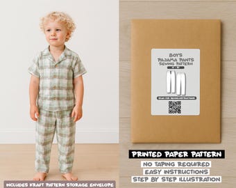 Op de afbeelding: Een kind draagt een groen-bruine geruite pyjama. Naast het kind staat een bruine papieren patroon-envelop met het label "Boys Pajama Pants Sewing Pattern". De tekst "Printed Paper Pattern" is ook zichtbaar.