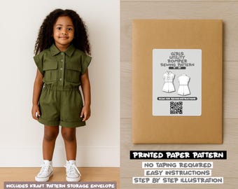 May include: A young girl wearing an olive green romper with a collared neckline, short sleeves, and pockets. Next to her is a brown paper pattern envelope with a white label that reads "Girls Utility Romper Sewing Pattern". The text "Printed Paper Pattern" is also visible.