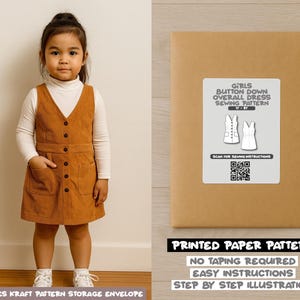 Op de afbeelding: Een jong kind draagt een bruine corduroy button-down overall jurk over een witte top met lange mouwen. De jurk heeft zakken en een V-hals. Er wordt ook een verpakking met een naaipatroon voor een meisjesoveralljurk getoond.