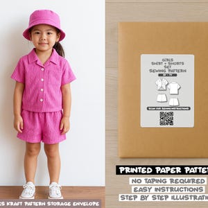 May include: A young child wearing a matching pink shirt, shorts, and bucket hat. The outfit is paired with white sneakers. Beside the child is a brown paper envelope with a white label that reads "GIRLS SHIRT + SHORTS SET SEWING PATTERN".