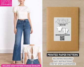 Può includere: Una donna indossa un top corto color crema con maniche a sbuffo e jeans blu. Una busta di carta marrone con un'etichetta che recita "Puff Sleeve Tie Back Crop Blouse Sewing Pattern". Il modello include un codice QR e il testo "Printed Paper Pattern".