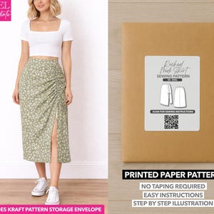 May include: A woman wearing a white crop top and a green floral print skirt with a side slit. Next to her is a brown paper pattern envelope with a label that reads "Ruched Mick Skirt Sewing Pattern". The text "Printed Paper Pattern" is also visible.