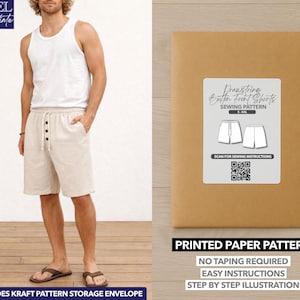 Pode incluir: Um homem vestindo uma regata branca e shorts bege com cordão e fecho de botão. Uma embalagem de papel marrom com um rótulo que diz "Drawstring Button Front Shorts Sewing Pattern" está à direita. A embalagem também diz "Printed Paper Pattern".