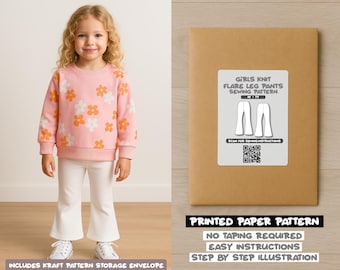 Op de afbeelding: Een jong meisje draagt een roze sweatshirt met oranje en witte bloemen en een witte flared broek. Rechts een kraftpapieren envelop met een naaipatroon voor meisjes flared broeken. De envelop leest "Girls Knit Flare Leg Pants Sewing Pattern".
