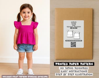 Op de afbeelding: Een jong meisje draagt een magenta top en een spijkerbroek. De top heeft een vierkante halslijn en gefranjerde mouwen. Een kraftpapieren envelop met een naaipatroonlabel staat rechts. Op het label staat "Girls Cute Top Sewing Pattern". De tekst "Printed Paper Pattern" is ook zichtbaar.