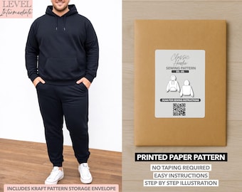 Peut inclure: Une personne porte un sweat à capuche noir et un pantalon de survêtement assorti, avec des baskets blanches. À côté, une enveloppe de patron en papier brun avec une étiquette blanche indiquant "Classic Hoodie Sewing Pattern". Le texte "Printed Paper Pattern" est également visible.
