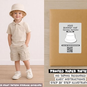 May include: A young child in a beige bucket hat, polo shirt, shorts, and white trainers. Beside the child is a brown paper pattern envelope with a white label that reads "KIDS BUCKET HAT SEWING PATTERN ONE SIZE". The envelope also says "PRINTED PAPER PATTERN".