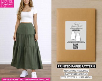 May include: An olive green tiered maxi skirt paired with a white crop top. A kraft paper envelope with a sewing pattern label is on the right. The label reads "Tiered Maxi Skirt Sewing Pattern" and includes a QR code and the text "Printed Paper Pattern".