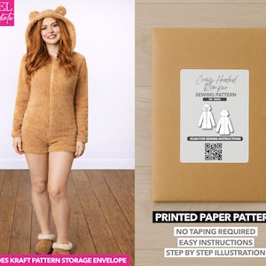 May include: A woman wearing a brown, hooded romper with bear ears. The romper has a zipper closure. A kraft paper envelope with a label that reads "Cozy Hooded Romper Sewing Pattern" is also shown. The text "Printed Paper Pattern" is visible.
