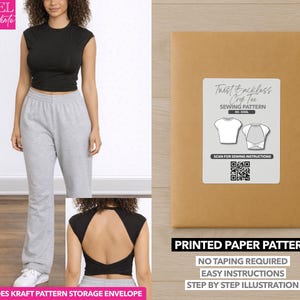 Könnte beinhalten: Eine Frau trägt ein schwarzes Crop-Top und eine graue Jogginghose. Das Bild zeigt auch einen braunen Papierumschlag mit einem weißen Etikett mit der Aufschrift "Twist Backless Crop Tee Sewing Pattern". Der Umschlag trägt auch die Aufschrift "Printed Paper Pattern".