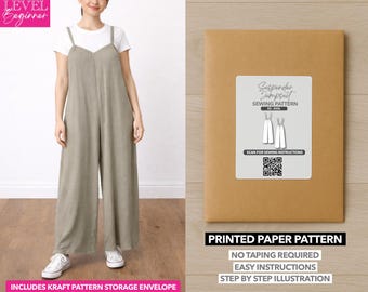 Può includere: Una donna indossa una tuta verde salvia e una maglietta bianca. Accanto a lei, una busta di carta marrone con un'etichetta che recita "Suspender Jumpsuit Sewing Pattern". È visibile anche il testo "Printed Paper Pattern".