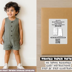 May include: A young child wearing a sage green button-down romper with pockets. Next to the child is a brown paper pattern envelope with a label that reads "Boys Button Down Romper Sewing Pattern". The envelope also states "Printed Paper Pattern".