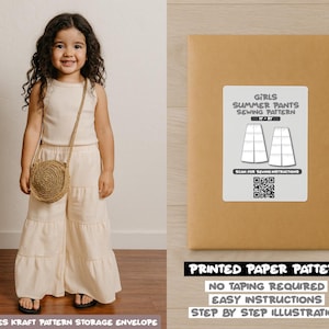 May include: A young girl wearing a cream-colored outfit and a round woven purse. Beside her is a brown paper envelope with a label that reads "GIRLS SUMMER PANTS SEWING PATTERN." The envelope also states "PRINTED PAPER PATTERN" and "NO TAPING REQUIRED."
