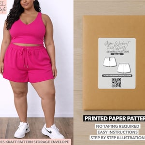 May include: A woman wearing a magenta workout set, consisting of a crop top and shorts. The image also shows a brown paper pattern envelope with a label that reads "Gym Workout Knit Shorts Sewing Pattern". The pattern includes a QR code and the text "Printed Paper Pattern".
