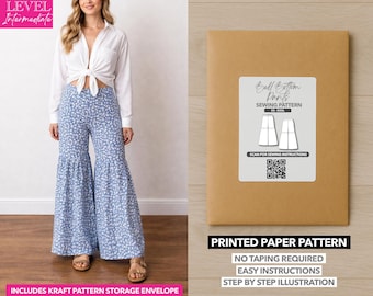 May include: A woman wearing blue floral bell-bottom pants and a white shirt. A brown paper pattern envelope with a label that reads "Bell Bottom Pants Sewing Pattern" is on the right. The text "Printed Paper Pattern" is below the envelope.