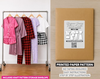 May include: A display of sleepwear sets and a printed paper pattern. The sleepwear includes a pink satin set, a mauve robe, red plaid pajamas, lavender pajamas, and a white crop top with black and white checkered shorts. The paper pattern is in a kraft envelope.