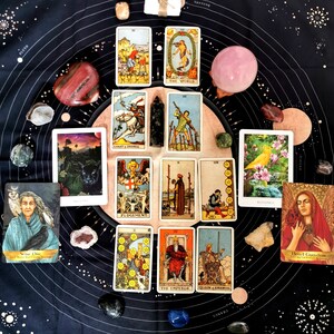 May include: Tarot card spread on a black background with crystals and stones. The cards include The World, Judgement, Knight of Swords, The Emperor, Queen of Swords, and Blessing. The text on the cards includes "The World", "Judgement", "Knight of Swords", "The Emperor", "Queen of Swords", and "Blessing".