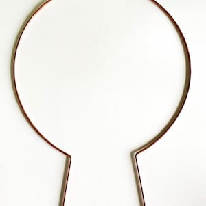 May include: A simple, brown metal headband with two straight ends.