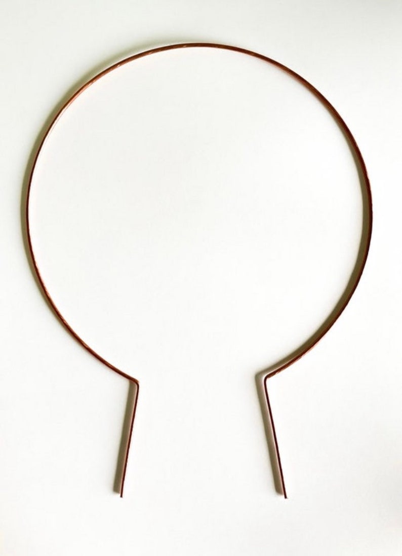 May include: A simple, brown metal headband with two straight ends.
