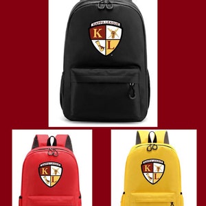 May include: Three backpacks in black, red, and yellow with a Kappa League logo featuring a shield with the letters K and L and a crossed lightning bolt and a quill.