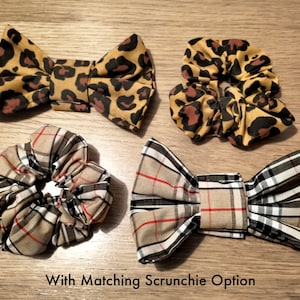 May include: Two hair scrunchies and two hair bows. One scrunchie and bow are brown and black with a leopard print. The other scrunchie and bow are brown, black, and white with a plaid pattern. The text "With Matching Scrunchie Option" is at the bottom of the image.
