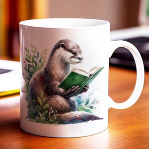 May include: White ceramic mug featuring a colourful illustration of an otter reading a green book. The otter is sitting on a bed of green leaves and flowers.