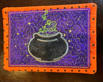 Cauldron Mug Rug, (5x 7) Purple and Orange Background, Black Cauldron with green bubbles.