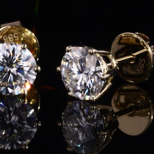 May include: A pair of gold stud earrings with large, round, clear gemstones. The earrings are marked "585" on the back.