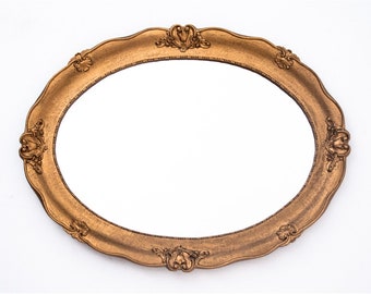 Miroir ovale dans un cadre doré.