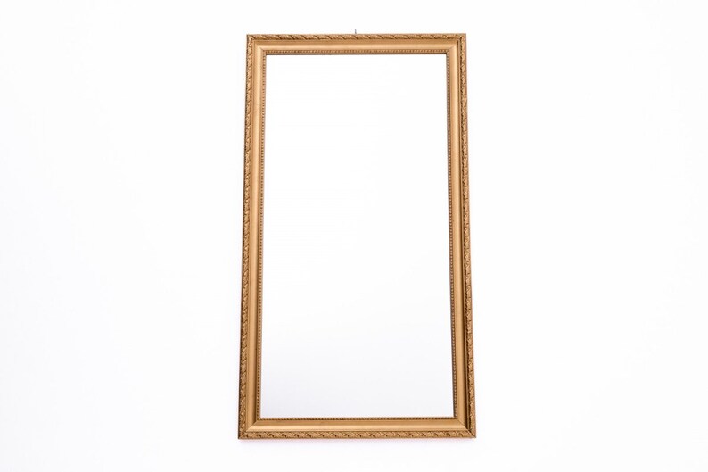 Pu&ograve; includere: Una cornice per foto rettangolare di colore dorato e decorata. La cornice &egrave; vuota e ha un design semplice ed elegante.