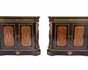 May include: A pair of black antique cabinets with gold accents and red and gold marquetry. The cabinets have marble tops and ornate carvings.