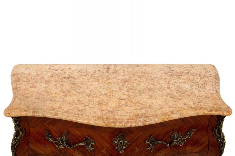 K&ouml;nnte beinhalten: Eine antike franz&ouml;sische Kommode mit einer Marmorplatte und aufwendigen Messingbeschl&auml;gen. Die Kommode ist aus Holz mit einem Marquetrie-Design.