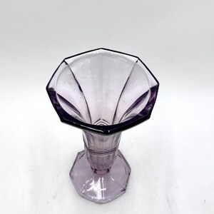 May include: A purple glass vase with a geometric design. The vase has a wide, octagonal opening and a narrow base.