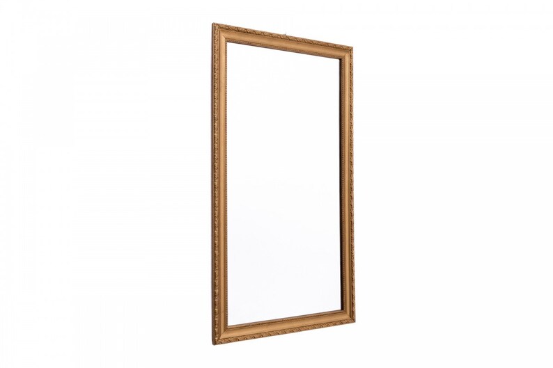 Pu&ograve; includere: Una grande cornice per quadri di forma rettangolare, di colore oro e decorata. La cornice ha un design decorativo in rilievo sui bordi.