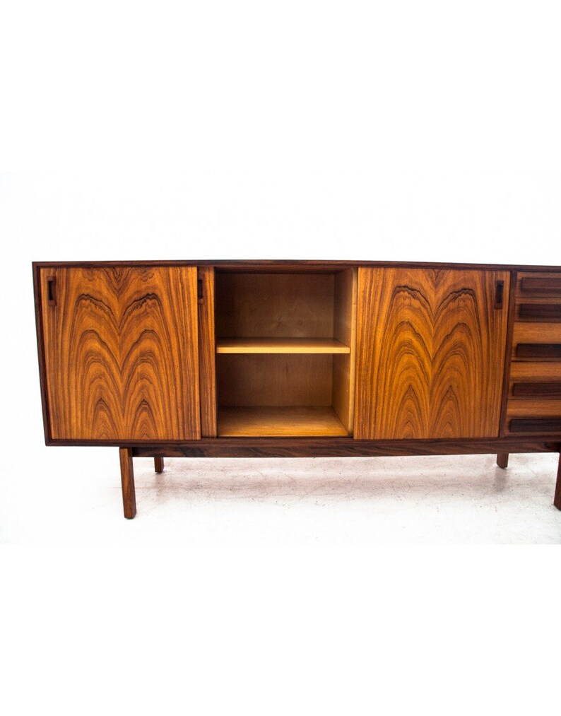 Peut inclure: Un buffet moderne du milieu du si&egrave;cle avec trois portes et une &eacute;tag&egrave;re. Le buffet est en bois fonc&eacute; avec un riche motif de grain. Les portes sont ferm&eacute;es et l'&eacute;tag&egrave;re est vide.