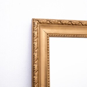 Pu&ograve; includere: Una cornice per foto dorata con un design ornamentale. La cornice ha un bordo rialzato e un bordo perlato.