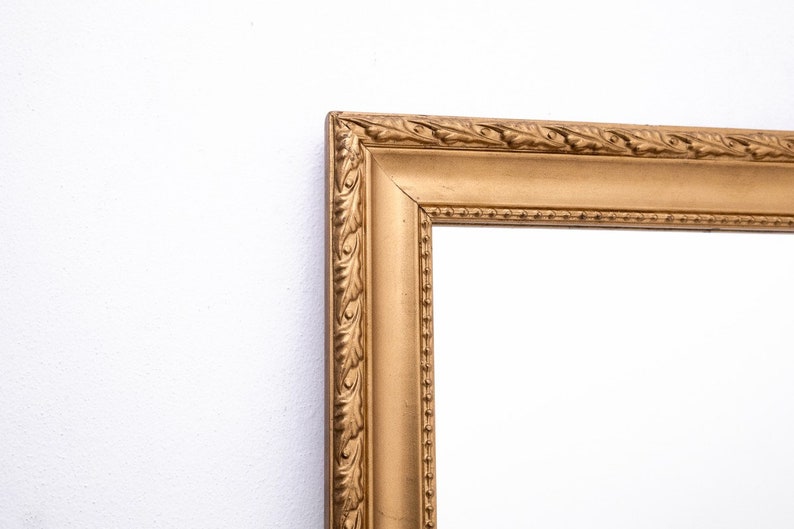 Pu&ograve; includere: Una cornice per foto dorata con un design ornamentale. La cornice ha un bordo rialzato e un bordo perlato.