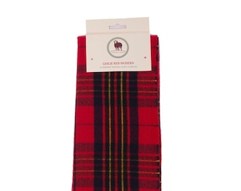 May include: Red and black plaid scarf with fringe. The scarf has a label that reads "Leslie Red Modern Pure Soft Tartan Clan Scarf".