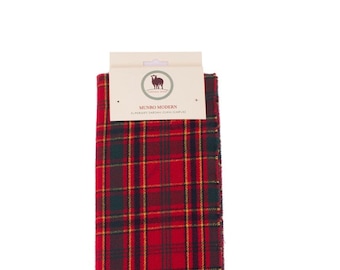 May include: Red, green, and yellow plaid scarf with fringe. The scarf has a label that reads "Munro Modern, Superior Tartan Clan Scarf".