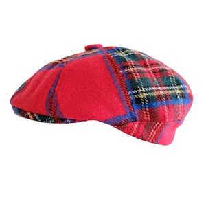 May include: A red and blue plaid newsboy cap with a button on top.