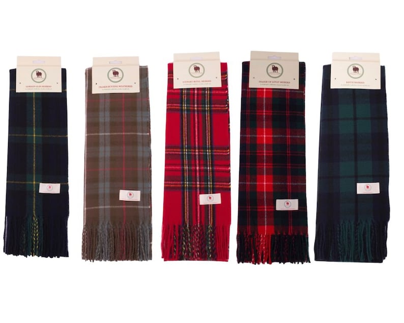 May include: Five different plaid scarves with fringe. The scarves are in various colors, including red, green, blue, and brown.