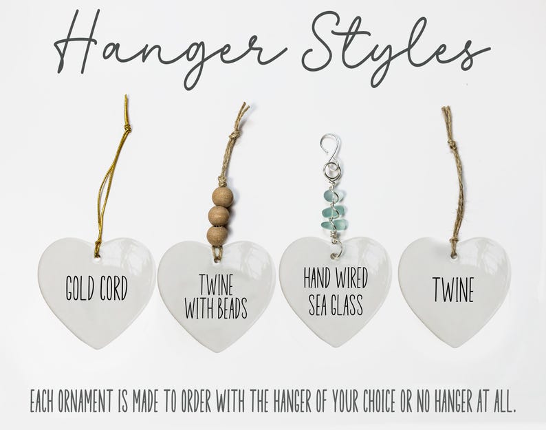 May include: Four white heart-shaped ornaments labeled Hanger Styles. The first has a gold cord, the second twine with beads, the third hand wired sea glass, and the fourth twine. Text reads: Each ornament is made to order with the hanger of your choice or no hanger at all.