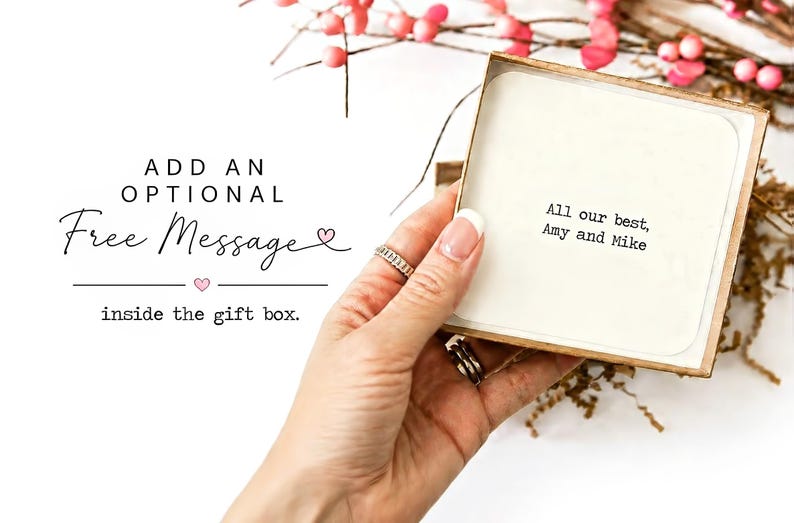May include: A square cardboard gift box containing a white card with the printed text: All our best, Amy and Mike. To the left, the text reads: ADD AN OPTIONAL Free Message inside the gift box, with small pink heart icons.