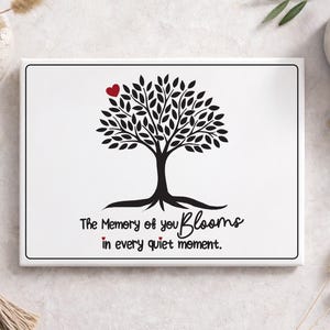 May include: A white canvas print featuring a black tree silhouette with a red heart and the text "The Memory of you Blooms in every quiet moment." The artwork is surrounded by decorative elements.