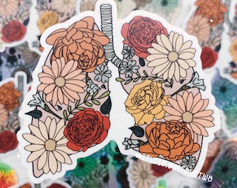 Könnte beinhalten: Ein Aufkleber mit einem Paar Lungen mit einem floralen Design. Die Lungen sind mit verschiedenen Blumen in Rot-, Orange-, Gelb- und Weißtönen gefüllt. Der Aufkleber ist auf weißem Hintergrund.