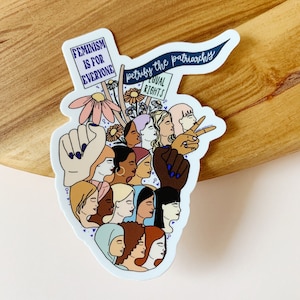 May include: A sticker with a feminist theme featuring a group of women of different races and ethnicities. The sticker includes the text "Feminism is for everyone" and "Petrify the patriarchy".