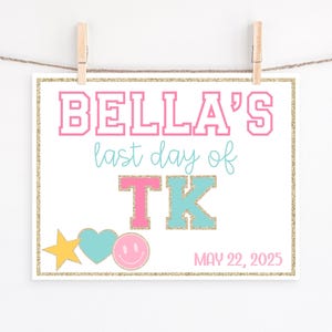 Puede incluir: Un letrero blanco con el texto "BELLA'S last day of TK" en rosa y turquesa. El letrero incluye un borde dorado brillante, una estrella, un corazón y una carita sonriente. También se muestra la fecha "MAY 22, 2025".