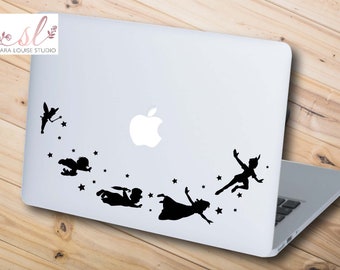 May include: Black and white silhouette sticker of Peter Pan and Tinkerbell flying with stars on a silver laptop.